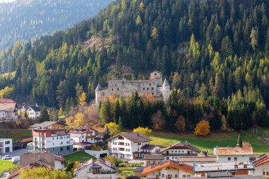 NAUDERS, TIROL, AUSTRIA - 16 Ekim 2022: Şehrin yukarısındaki bir tepenin üzerine inşa edilmiş antik bir şatonun sonbahar manzarası