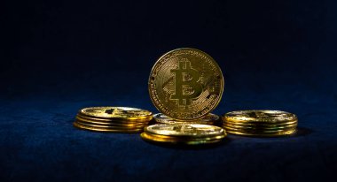 Altın Bitcoin, Bitcoin 'in ortasındaki yığın üzerinde koyu mavi arkaplan