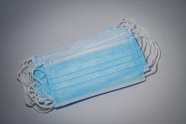 Mavi cerrahi maskeler gri arkaplanda, bakteri koruma konsepti.