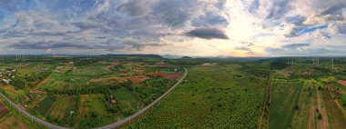 Doğaya dost yeşil enerjiden beslenen günbatımı ve mavi gökyüzü ile kırsal alanın geniş bir görüntüsü..