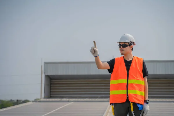 Asian engineers wearing protective vest and white hardhat standi