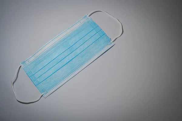 Blaue Chirurgenmaske Mit Gummi Ohrenbändern Auf Grauem Hintergrund Bakterienschutzkonzept — Stockfoto