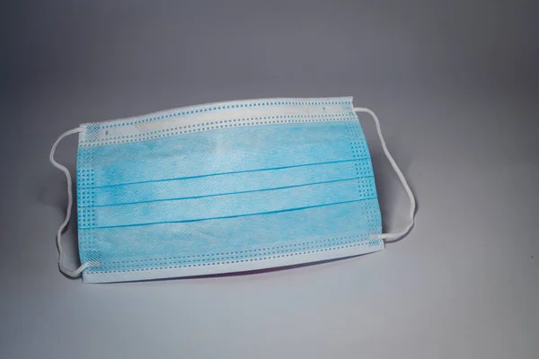 Blaue Chirurgenmaske Der Mitte Auf Grauem Hintergrund Bakterienschutzkonzept — Stockfoto