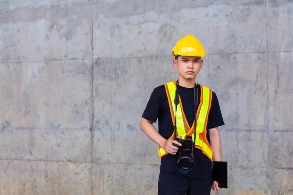 모자와 안전모를 착용하고 아시아의한 기술자는 손에는 카메라를 손에는 현장에서 태블릿을 — 스톡 사진