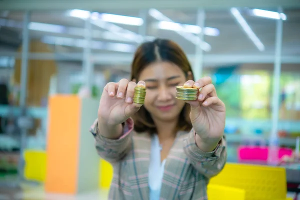 若い美しいアジアのビジネス女性は彼女の目を閉じてカメラに向かって黄金のコインを開催 — ストック写真