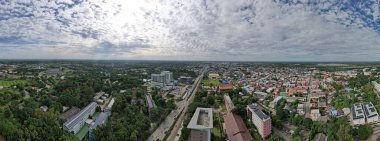Binalar ve sokaklar arasında birbirine karışan yeşil ağaçların panoramisi, kentin beton ve çeliğiyle tezat oluşturan ferahlatıcı bir doğal temas sağlıyor..