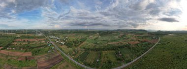 Kırsal ve yel değirmenlerinin panoramik görüntüsü. Yeşil orman gri bulutu güneş ışığı, yenilenebilir enerji, çevresel koruma..