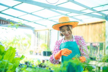 Güzel Asyalı çiftçinin gülümsemesi doğayla ve dünyayla bağ kurmanın neşesini yansıtıyordu. Akıllı çiftlik..