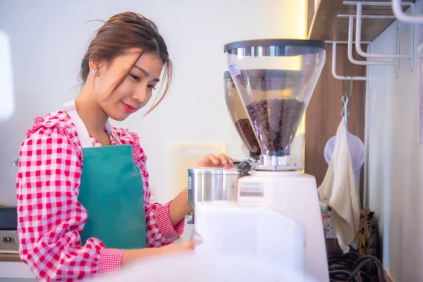 Beautiful asian coffee shop worker is expertly handling the coffee machine, Business and finance, Smart technology.
