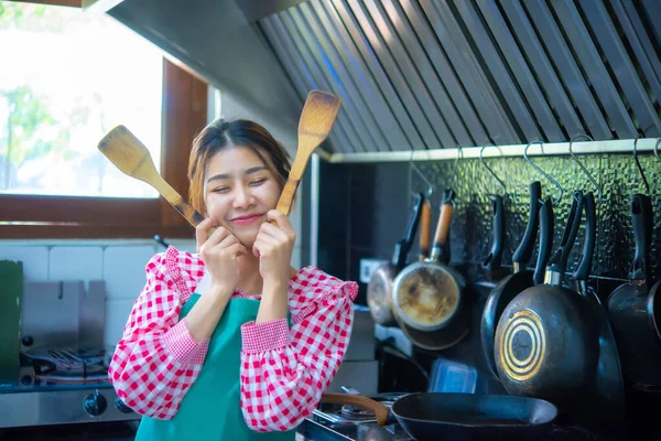 아시아인의 아름다운 요리사는 양손으로 부엌에서 얼굴에 미소를 머금고 앞치마를 — 스톡 사진
