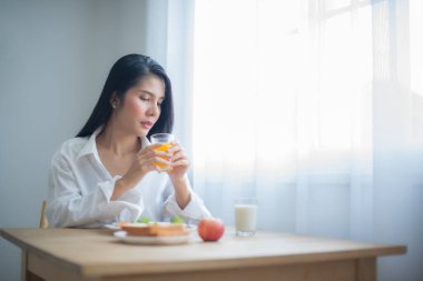 Güzel Asyalı kadının gözleri fotokopi odasına sabitlenmişti. Meyve suyunu sabit bir elle tutuyordu..