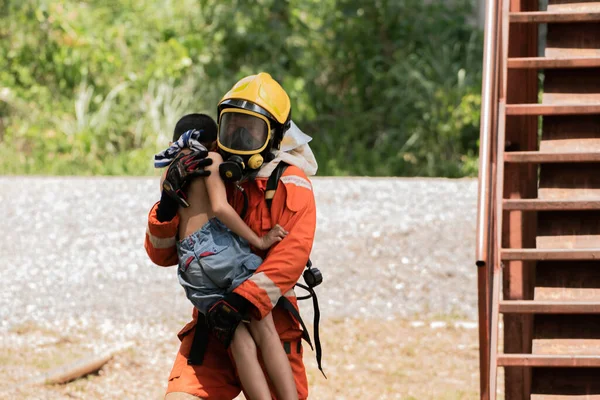 消防队员把孩子抱出危险的地方 用勇敢的心保护人们 穿制服的英雄把孩子们从危险中解救出来 — 图库照片
