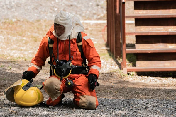Seorang Petugas Pemadam Kebakaran Sedang Duduk Berlutut Melepas Topinya Karena — Stok Foto