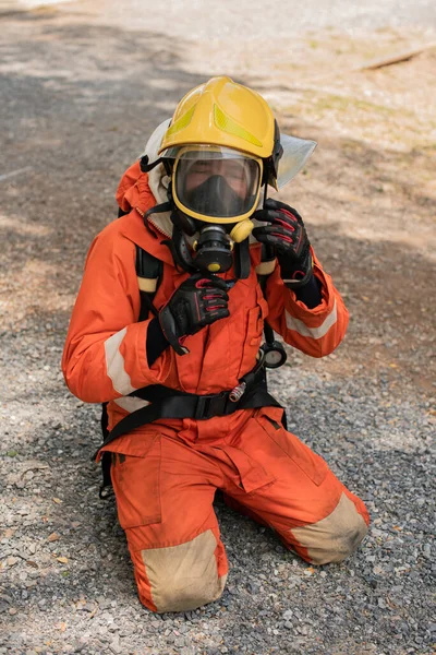 Vertical Picture Firefighter Sits His Knees Taking His Helmet — Stock Photo, Image
