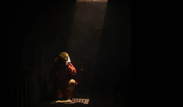 Bombeiro Está Sentado Lado Uma Escada Vermelha Uma Sala Escura — Fotografia de Stock