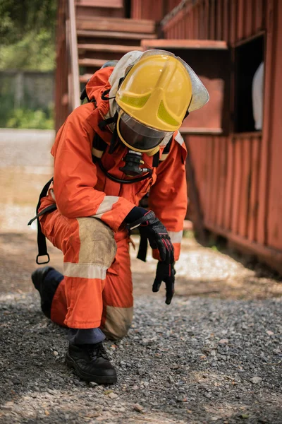 Gambar Vertikal Seorang Pemadam Kebakaran Duduk Berlutut Dan Melihat Bawah — Stok Foto