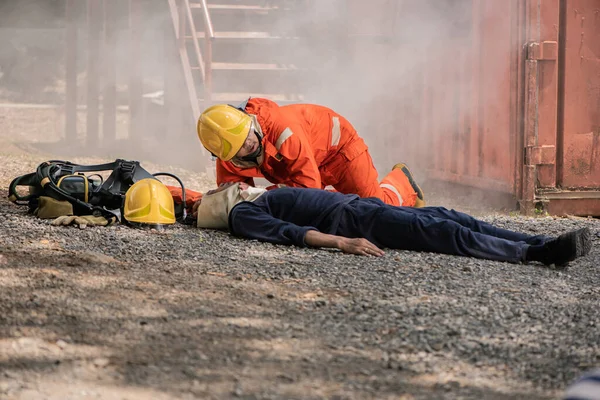 消防士たちは床の上に横たわっている犠牲者に近づいて危険の兆候を確認し 人々を救う — ストック写真