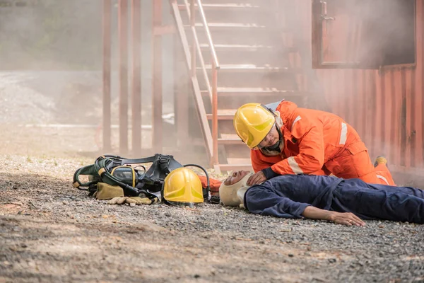床に横たわっていた犠牲者の脈を確認する消防士 一日も早く人々を救うために — ストック写真