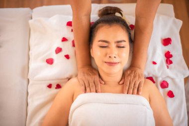 Profesyonel masöz yetenekli ellerini kullanarak güzel Asyalı müşterisine rahatlatıcı bir masaj yapıyor..