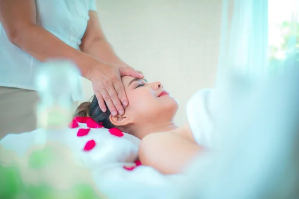 Professionelle Masseurin Kopfmassage Für Frau Client Auf Bett Mit Rosenblättern — Stockfoto