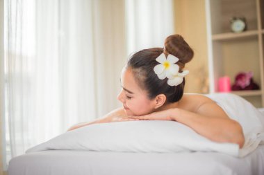 Güzel Asyalı kadın, kaplıca odasında gözleri kapalı ve yana dönük bir şekilde yatıyordu..