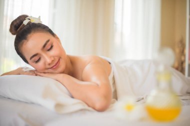 Güzel Asyalı kadın yatakta yatarken zihnini boşaltıyor ve gelecekte zorluklarla karşılaşmaya hazır hissediyor..