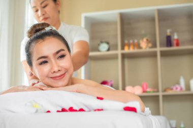 Güzel Asyalı müşteri, beyaz yatakta masajdan zevk alırken tamamen rahatlamış görünüyor..