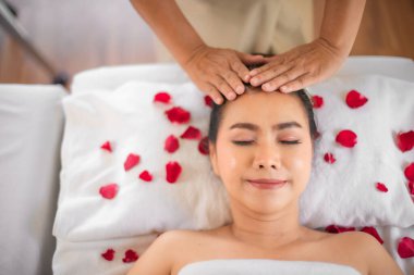 Güzel Asyalı müşterinin yüzü huzurlu ve huzurlu masajın harikalar yarattığını gösteriyor..