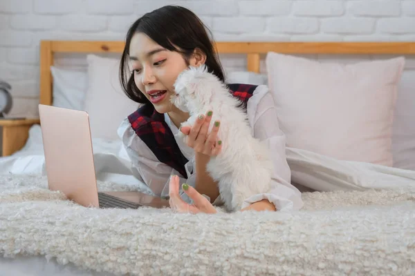 Despite being busy the Asian girl takes a moment to pet the dog and give it some attention reminding herself of the importance of balance in life.