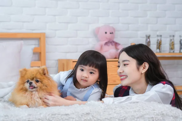 Beautiful asian girl and little girl looked at the dog with pure joy happiness that the furry friend brought to them.