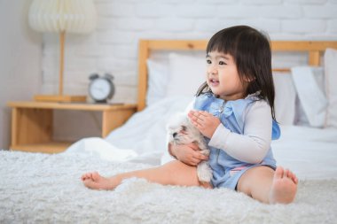 Köpek, yatak odasında fotokopi odasına bakarken sevgi ve şefkatle küçük kızın kucağında mutlu görünüyordu..