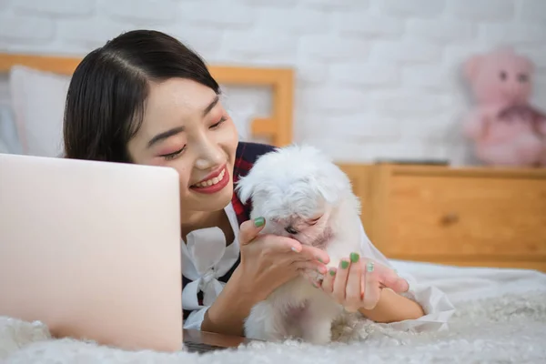 The bond between the beautiful asian girl and the little dog grew stronger with each passing moment as they shared both the excitement of playtime and the sense of accomplishment in getting work done.