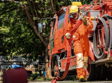 Senkronize hareketlerle itfaiyeciler hızla yangın hortumlarını itfaiye araçlarından çıkardılar önlerindeki alevli cehennemle mücadele etmeye hazırdılar..
