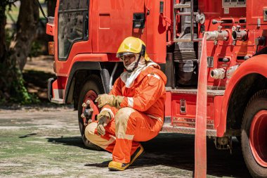 İtfaiyeci yorulmuştu. İtfaiye arabasının yanında oturuyordu..