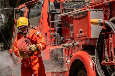 İtfaiyeci titizlikle su hortumunu kavrıyor ve yangına karşı koymanın ve dumanla boğuşmanın özünün zaman olduğunu biliyor..