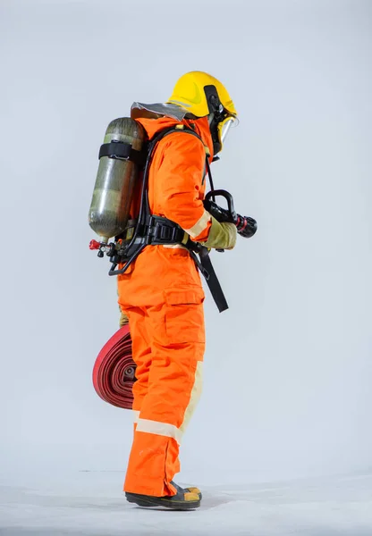 消防士の垂直写真は背が高く 勇敢に火と戦う人々の回復力と準備を示すカメラに背を向けて自信を持って立っていた — ストック写真