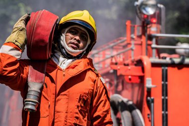 İtfaiyecinin sarsılmaz azmi, eldeki işe odaklanmaya devam ederken, zorlu koşullardan yılmadan dumanın içinde parlıyor..