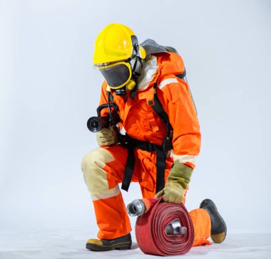Parlak sarı miğfer ve itfaiyecinin eldivenleri saf beyaz arka plana karşı durarak tehlike karşısında bir koruyucu ve muhafız olarak rollerini vurguluyor..