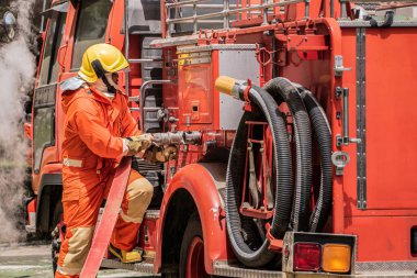 İtfaiyeci, itfaiye aracının itfaiye hortumunu güvenli bir şekilde fişe takarak yangın kurbanlarına acil yardım için güvenilir bir bağlantı sağlıyor..