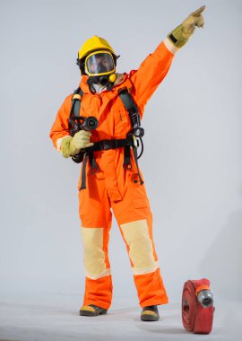 İtfaiyecinin dikey resmi, beyaz arka planda bir yangın hortumu dururken ve sağ üst tarafı işaret ederken..