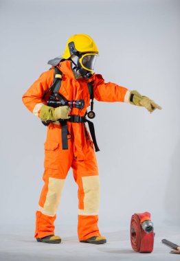 Sağlam bir duruş ve geniş bir kolla itfaiyeci parmaklarını işaret eder. Odaklanmayı ve acil bir duruma verilen yanıta rehberlik eder..