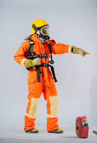 Вертикальна Картина Пожежника Стоїть Вказує Палець Бік Пожежний Шланг Підлозі — стокове фото