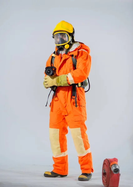 消防士の活気ある保護具ときれいな白い背景のコントラストは 緊急時の対応における彼らの重要な役割に注目を集めています — ストック写真