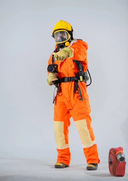 Вертикальна Картина Пожежника Стоїть Вказує Палець Камеру Пожежний Шланг Підлозі — стокове фото