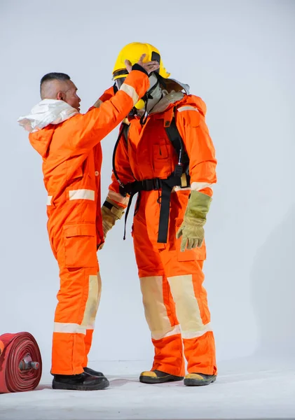 不動の集中力で 消防士は訓練と経験を活用してストラップを専門的に外し パートナーが自由に呼吸できるマスクを解放します — ストック写真