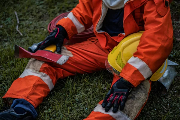 Pemadam Kebakaran Duduk Rumput Sambil Memegang Kapak Besi Dalam Tembakan — Stok Foto