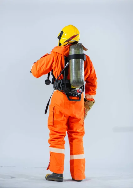 彼の背中に酸素タンクと消防士は命を救う任務を遂行しながら個人の安全を確保するための彼のコミットメントを強調 — ストック写真