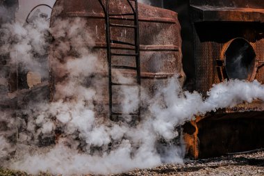 Paslı bina, yangının yıkıcı etkilerini ve durumu kontrol altına almak için hızlı ve kararlı bir eylem gereğini yansıtan heybetli bir zemin görevi görüyor..