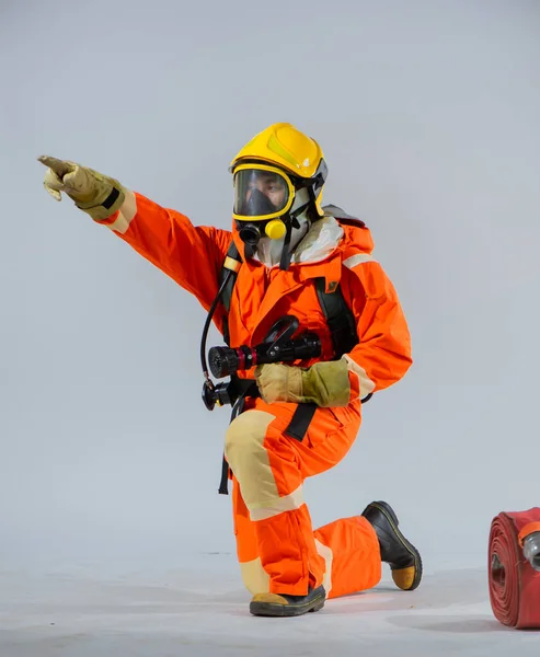 Вертикальне Зображення Показує Пожежника Який Сидить Тримає Пожежний Шланг Вказуючи — стокове фото