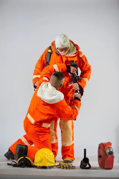 集中力で消防士は最適な性能のための適切な機器の準備の重要性を強調安全かつ快適なフィットを確保腰ベルトを調整します — ストック写真